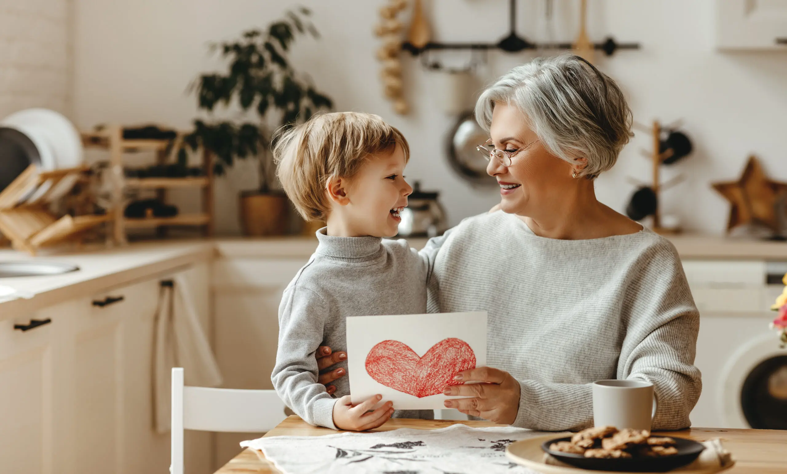 happy family grandson child congratulates grandmother on holiday and gives card