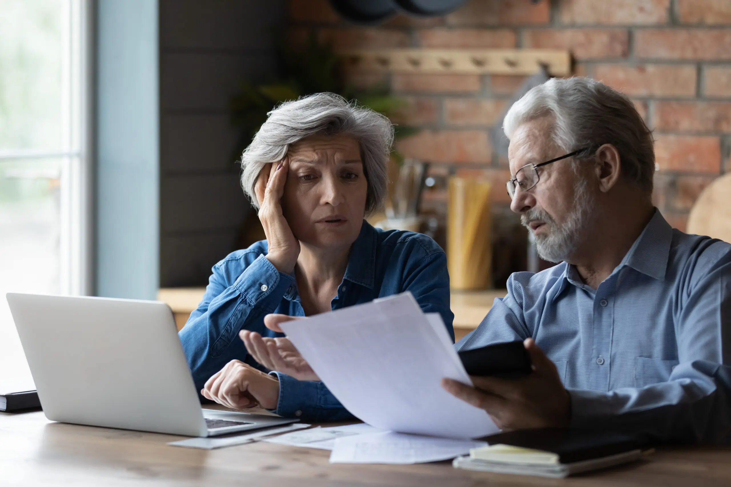 Concerned elderly couple discuss unpaid bank debt