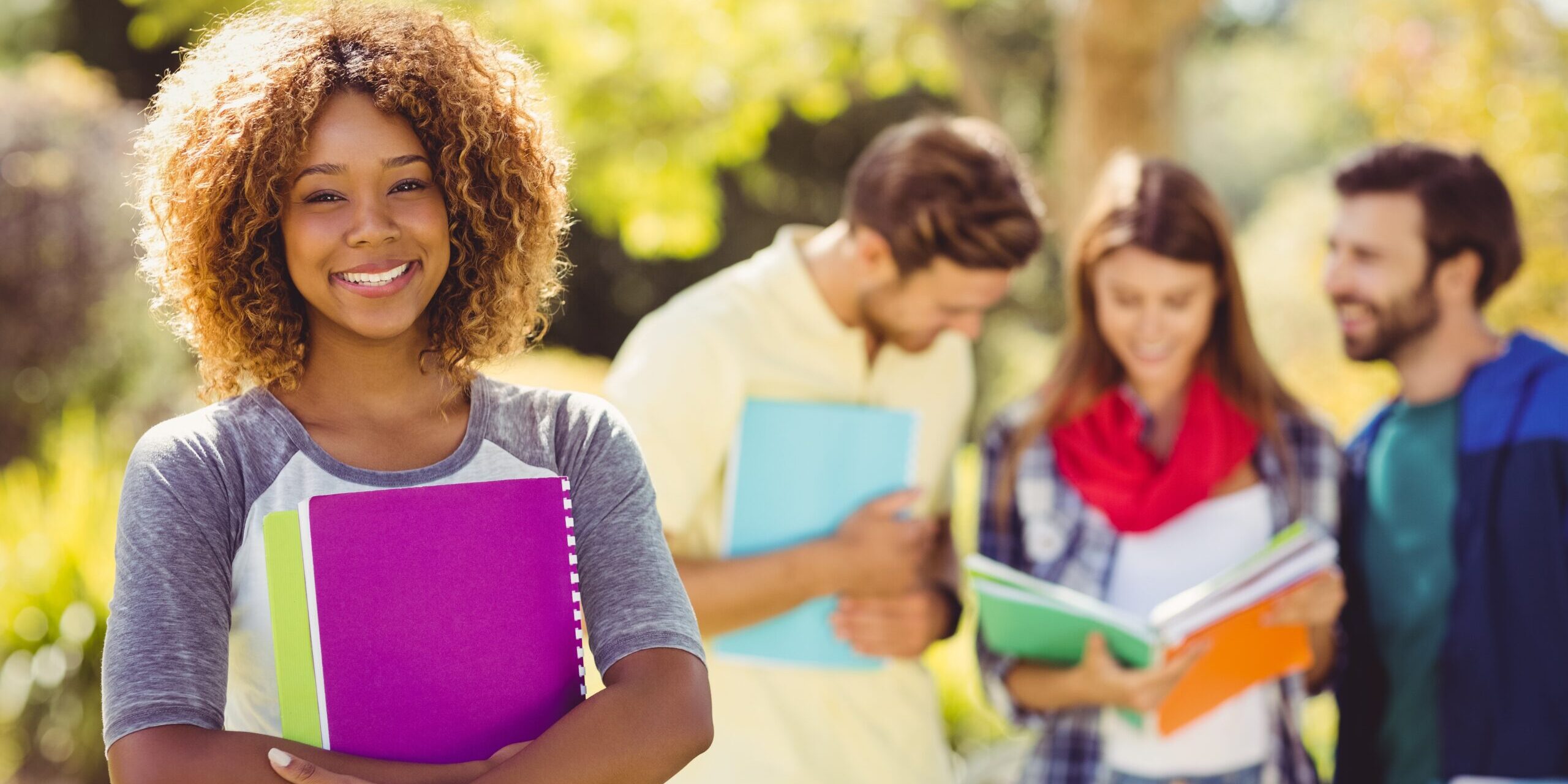Portrait of college girl holding notes with friends