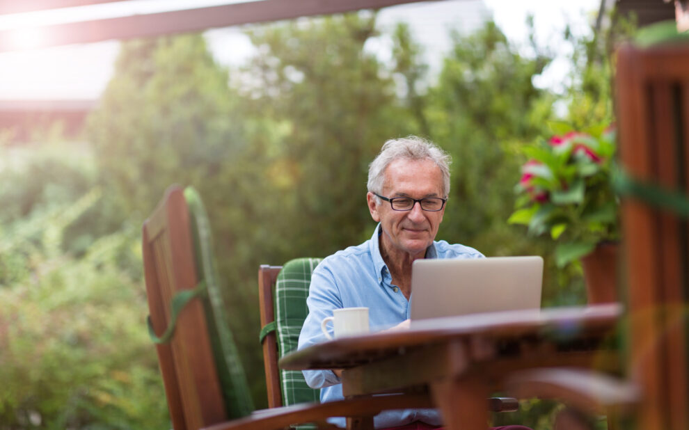 Senior man working on laptop in the garden