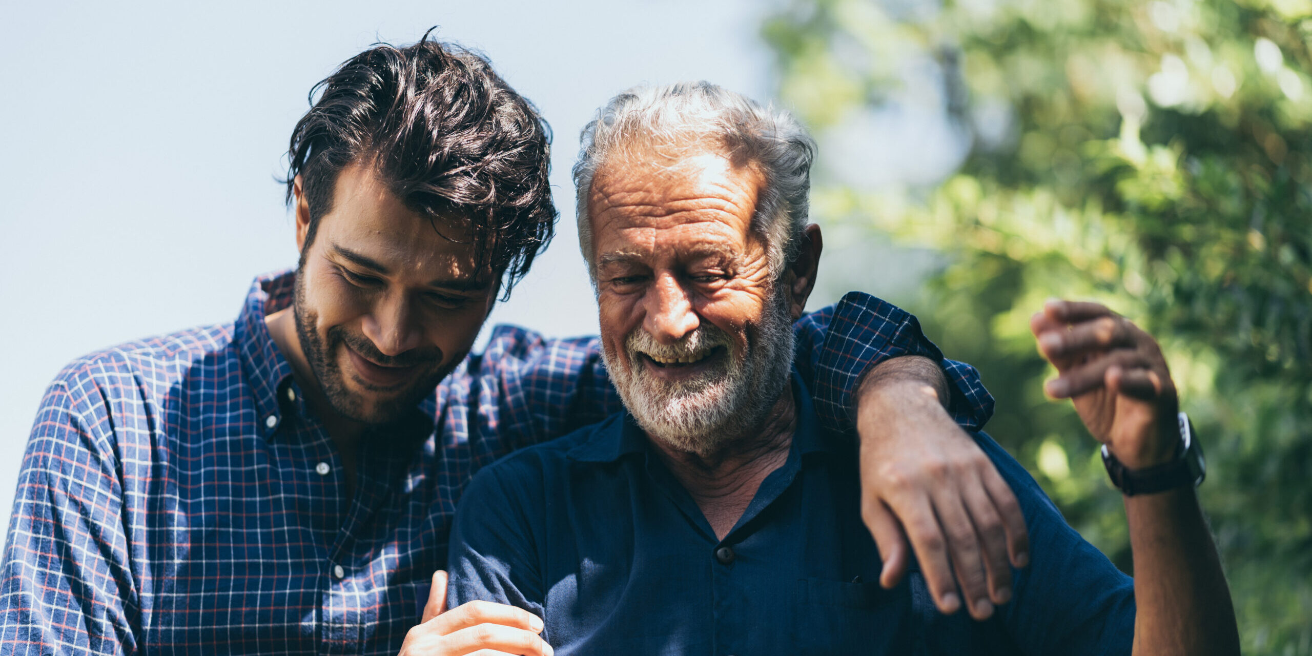 An adult hipster son and senior father at home, talking.