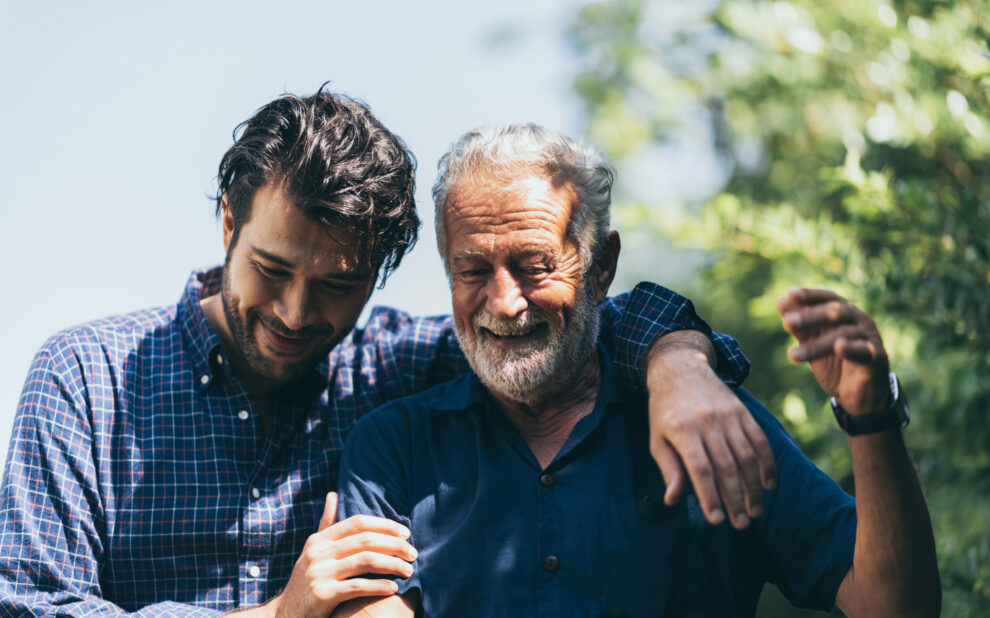 An adult hipster son and senior father at home, talking.
