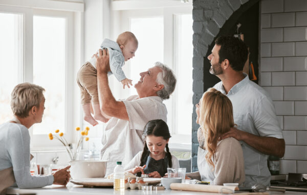 .Family, kitchen and grandpa playing with baby having fun, bonding and relax together. Big family, support or care of grandfather carrying newborn with mother, father and girl child cooking in house. inheritance tax planning