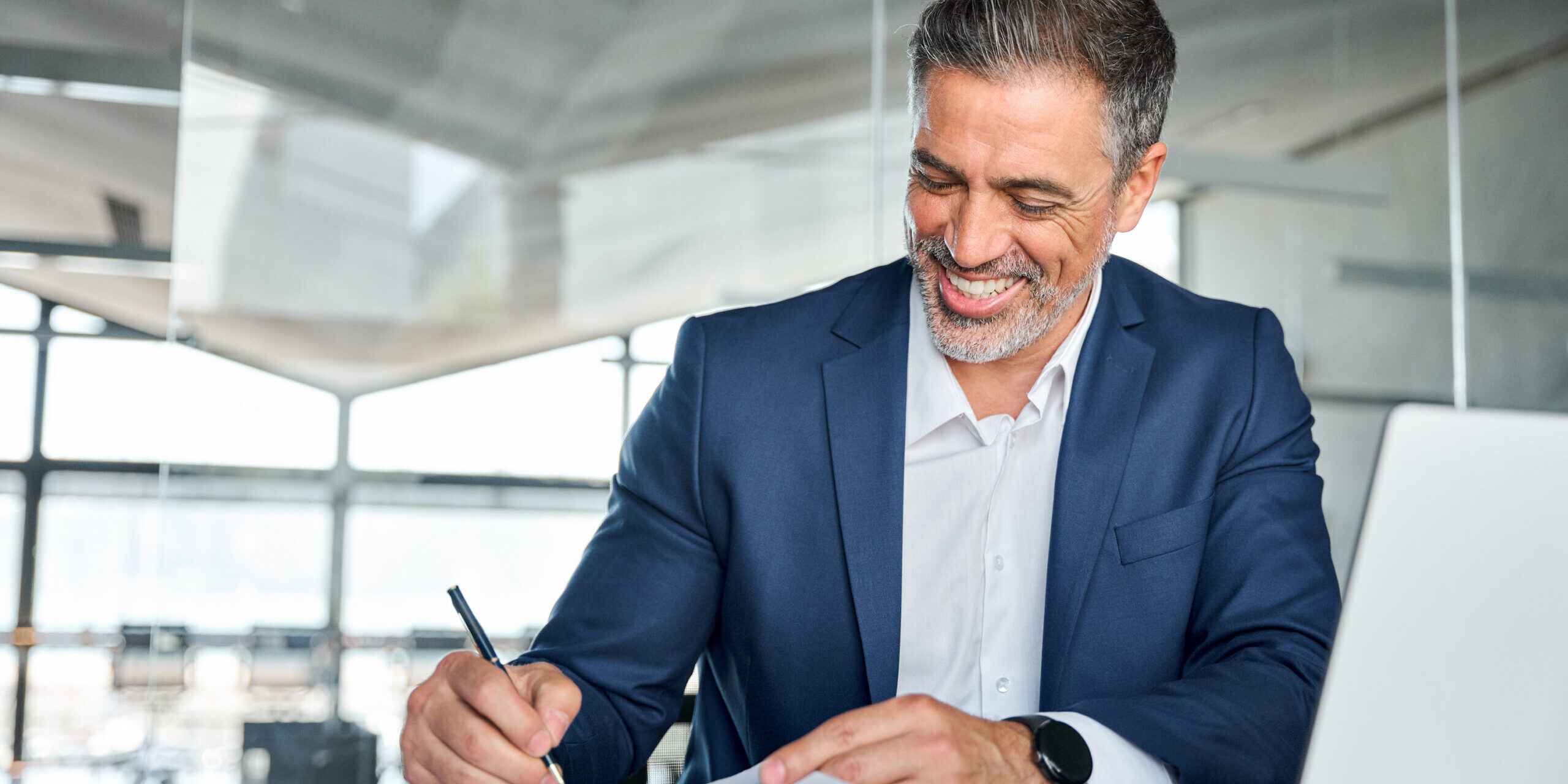 Happy satisfied middle aged professional business man signing documents. Business Owner Life Insurance