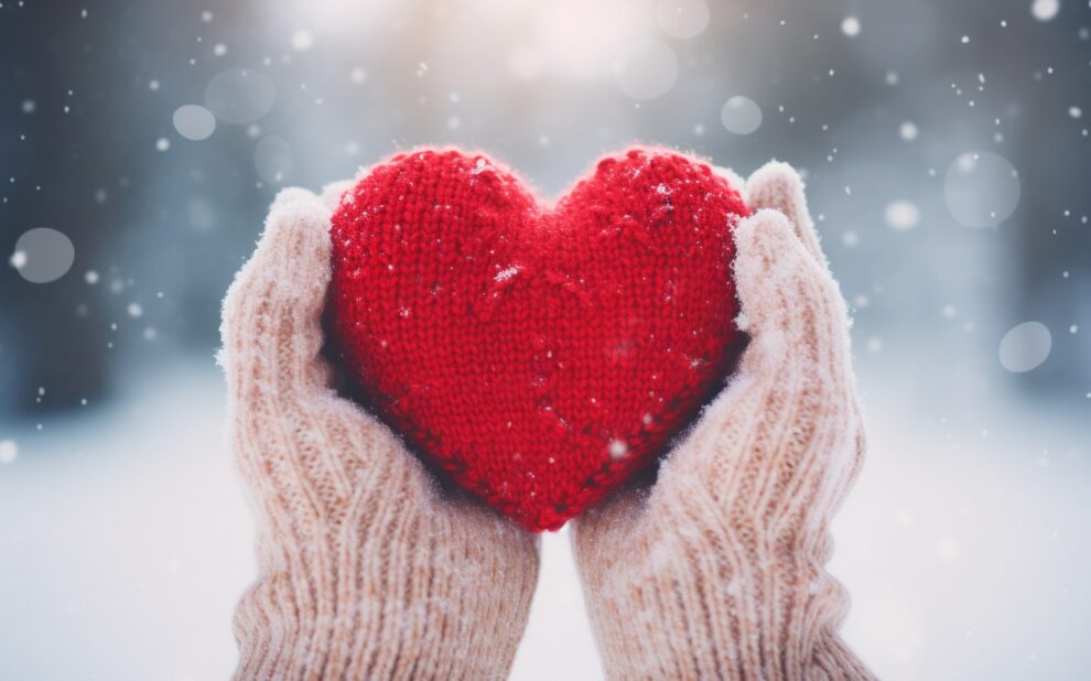 Hands holding a red heart with wooden mittens. Generative ai. year-end charitable giving year end charitable giving