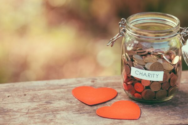 Money jar full of coins for charity and a couple of heart shapes donor advised fund rules